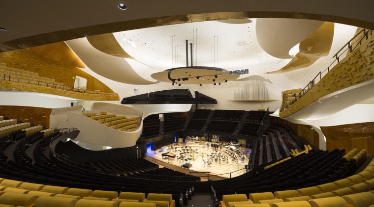 The auditorium at the Philharmonie de Paris was architecture, auditorium, ceiling, light, lighting, performing arts center, theatre, tourist attraction, yellow, brown