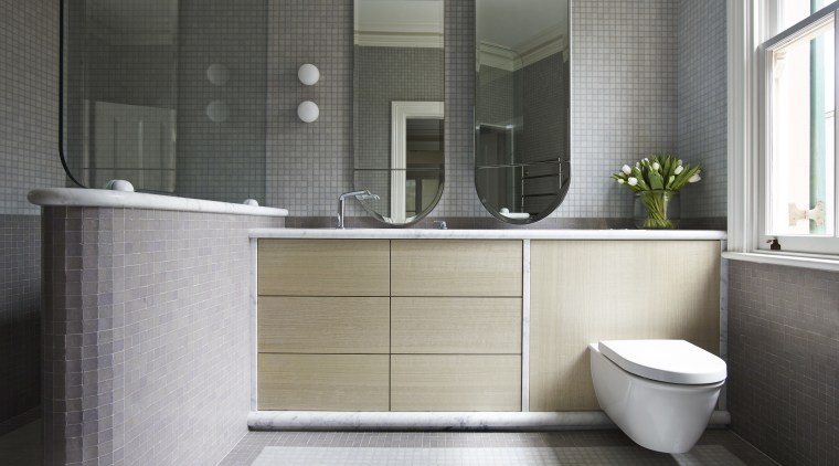 This ensuite has a near-identical aesthetic to the bathroom, bathroom accessory, floor, interior design, plumbing fixture, product design, room, sink, tile, gray