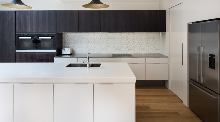 Contrasting the mainly crisp, clean surfaces, the splashback cabinetry, countertop, cuisine classique, floor, home appliance, interior design, kitchen, product design, room, wood flooring, gray