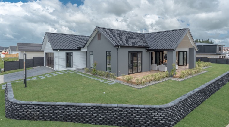 This twin-gabled, two-tone showhome by Landmark Homes area, cottage, elevation, estate, facade, grass, home, house, land lot, landscape, lawn, property, real estate, residential area, roof, siding, suburb, yard, gray, green