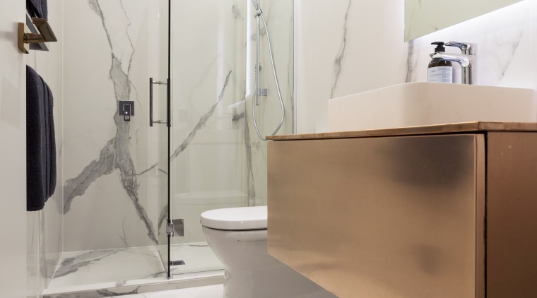 In all three bathrooms in this project, the bathroom, floor, flooring, interior design, plumbing fixture, product design, room, sink, tap, tile, wall, gray