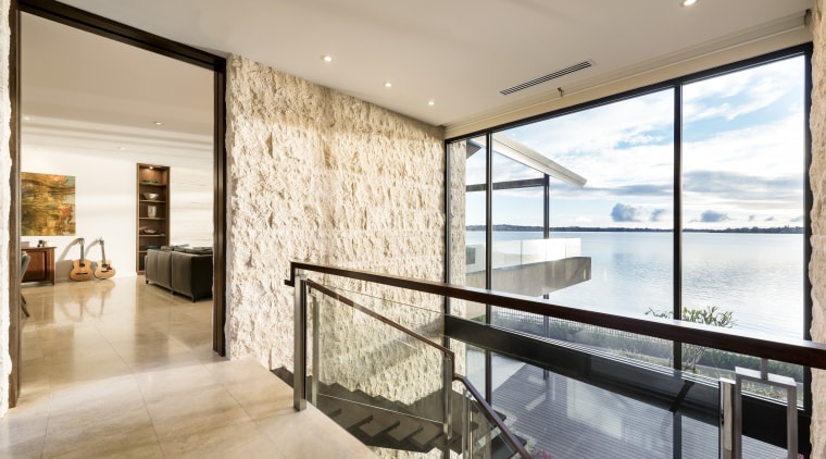 Stone exteriors wrap around to form interior walls apartment, architecture, condominium, estate, home, house, interior design, living room, penthouse apartment, property, real estate, window, gray
