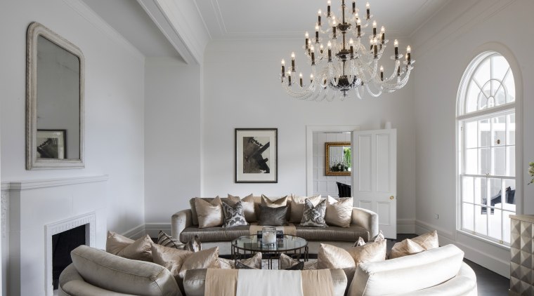 A large chandelier is the centrepiece of this ceiling, estate, furniture, home, interior design, living room, room, table, gray