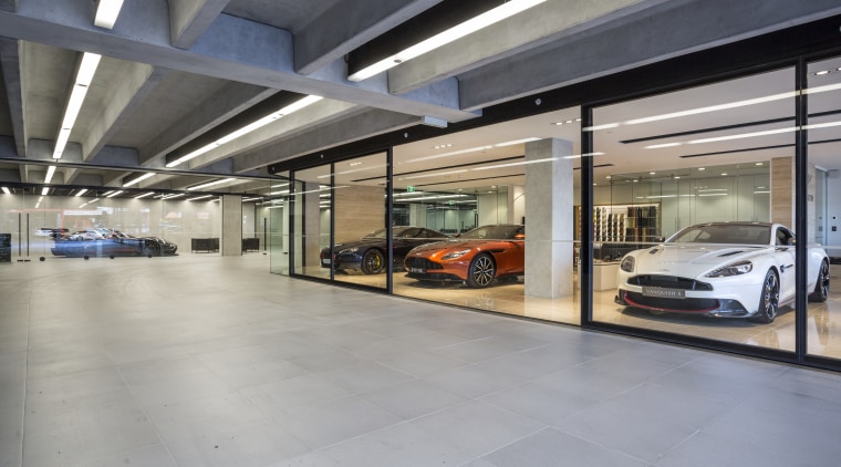 Large-format, matt concrete pavers provide a unifying refined automotive design, car, car dealership, executive car, garage, luxury vehicle, motor vehicle, parking, gray