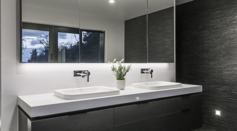 Under-vanity lighting highlights the stone-look flooring in this architecture, bathroom, ceiling, countertop, floor, interior design, product design, room, sink, gray, black