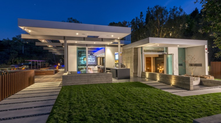 The board-formed concrete wall seen behind the barbecue architecture, backyard, elevation, estate, facade, home, house, lighting, property, real estate, residential area, roof, villa, brown