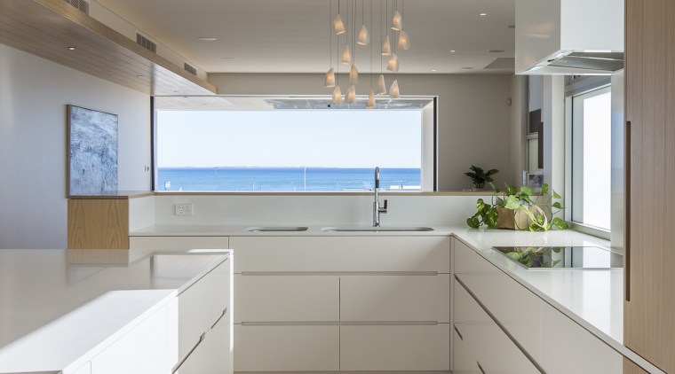 This crisp white and wood kitchen part of cabinetry, countertop, ceasarstone, benchtop, travertine floor, kitchen, Craig Steere
