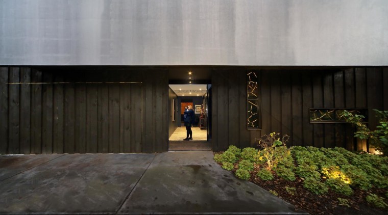 Positioned in a side lane, the front door architecture, facade, home, house, property, real estate, black, gray