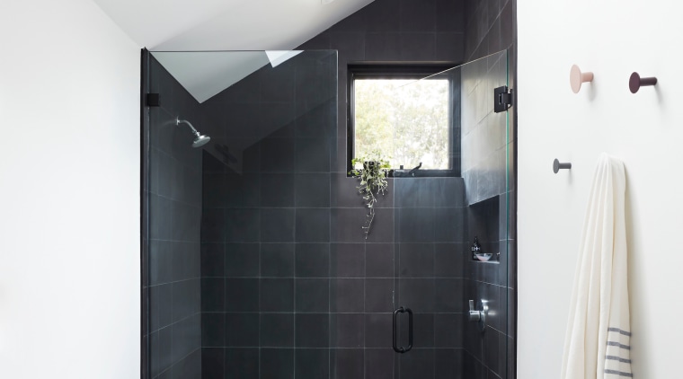 The primary bathroom showcases floor-to-ceiling tiles and a 