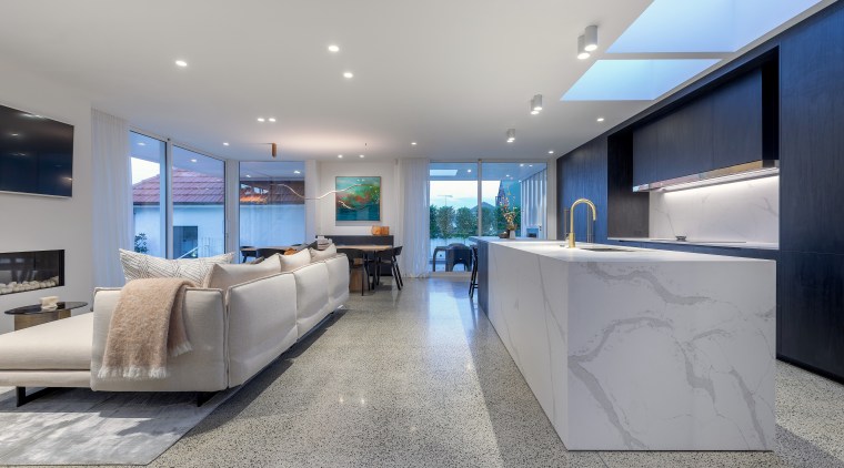 A light-toned, marble-look island together with the skylights 