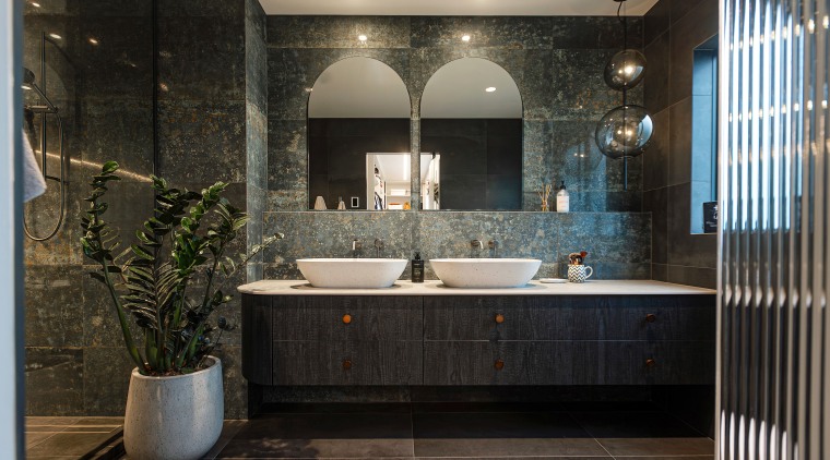 The bathroom has a moody meets natural vibe. 
