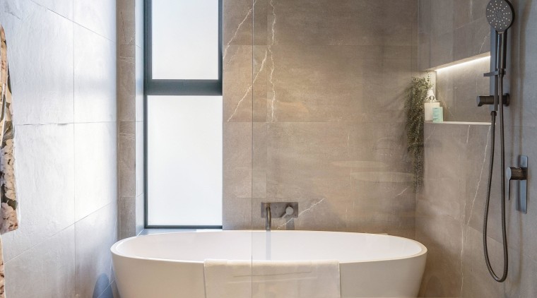 The freestanding tub is situated at the end 