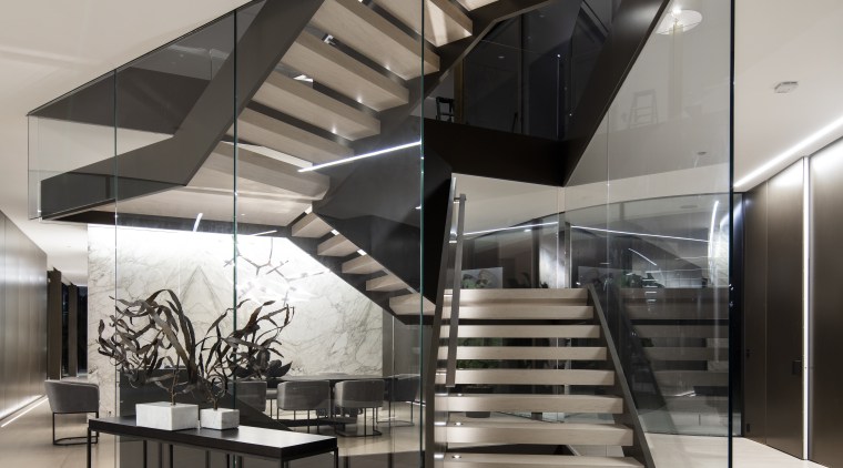 ​​​​​​​Visitors encounter a dynamic glass and steel staircase architecture, black-and-white, building, ceiling, daylighting, design, floor, limestone floor,  stair, staricase, glass, handrail, house, interior design, line, lobby, material property, metal, real estate, room, stairs, gray