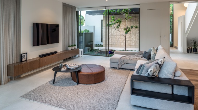 In a home that’s all about connections, this apartment, architecture, building, ceiling, coffee table, estate, floor, flooring, furniture, home, house, interior design, living room, lobby, property, real estate, room, table, tile, gray