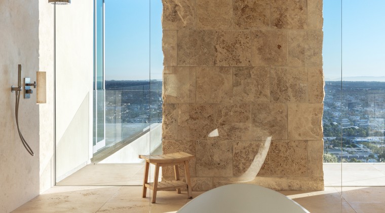 Stone blocks and glass semi-enclose the understated shower 