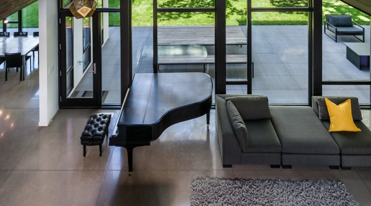 Despite the hard surfaces such as the concrete architecture, ceiling, daylighting, home, house, interior design, lobby, structure, black