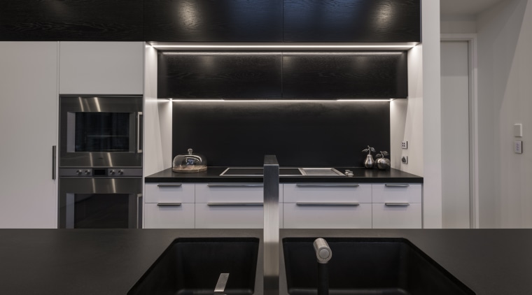 On this project, wood panelling concealing the rangehood cabinetry, countertop, interior design, kitchen, kitchen stove, product design, black, gray