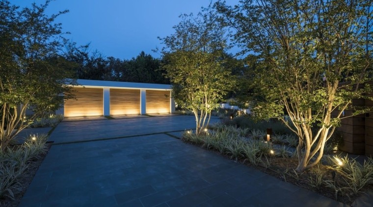 Sited on top of a hill, this home architecture, backyard, cottage, estate, facade, home, house, landscape, landscape lighting, lighting, plant, property, real estate, residential area, shed, siding, sky, tree, yard, blue