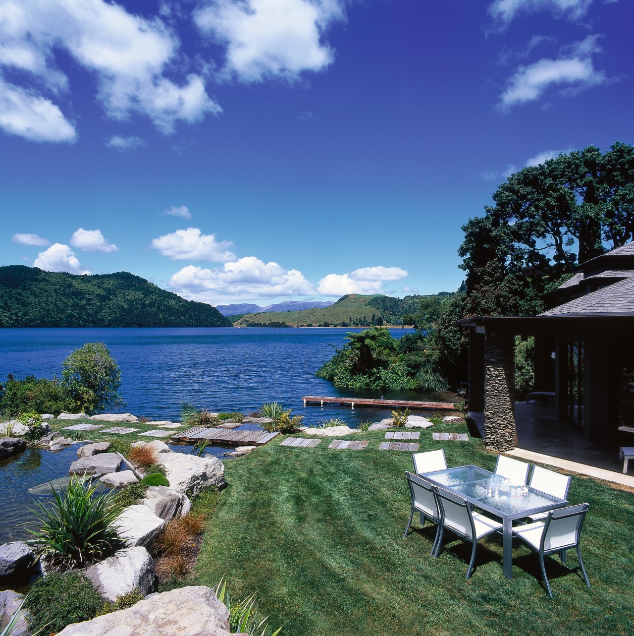 View of the outdoor dining area backyard, cloud, cottage, estate, home, house, lake, landscape, leisure, mountain, property, real estate, resort, sky, swimming pool, tree, vacation, villa, water, blue