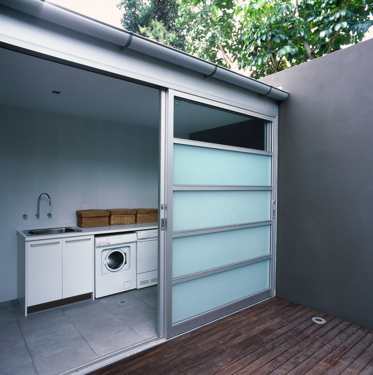 View of laundry room with white appliances and door, garage, window, gray, black