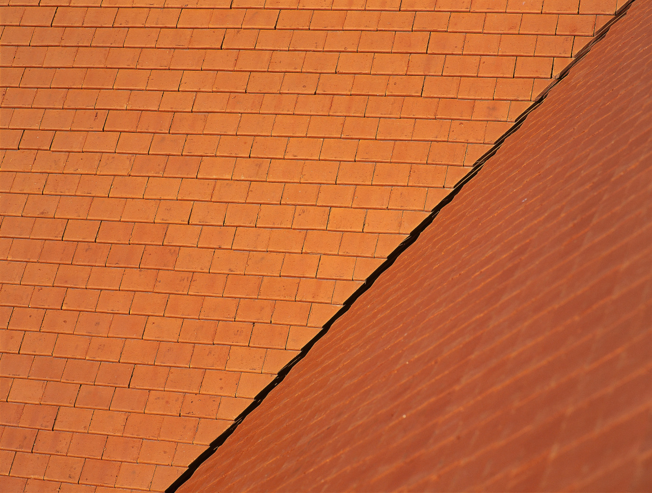 Steeply pitched roof with terracotta roof tiles, with angle, brick, brickwork, line, material, orange, roof, sky, wall, wood, wood stain, orange