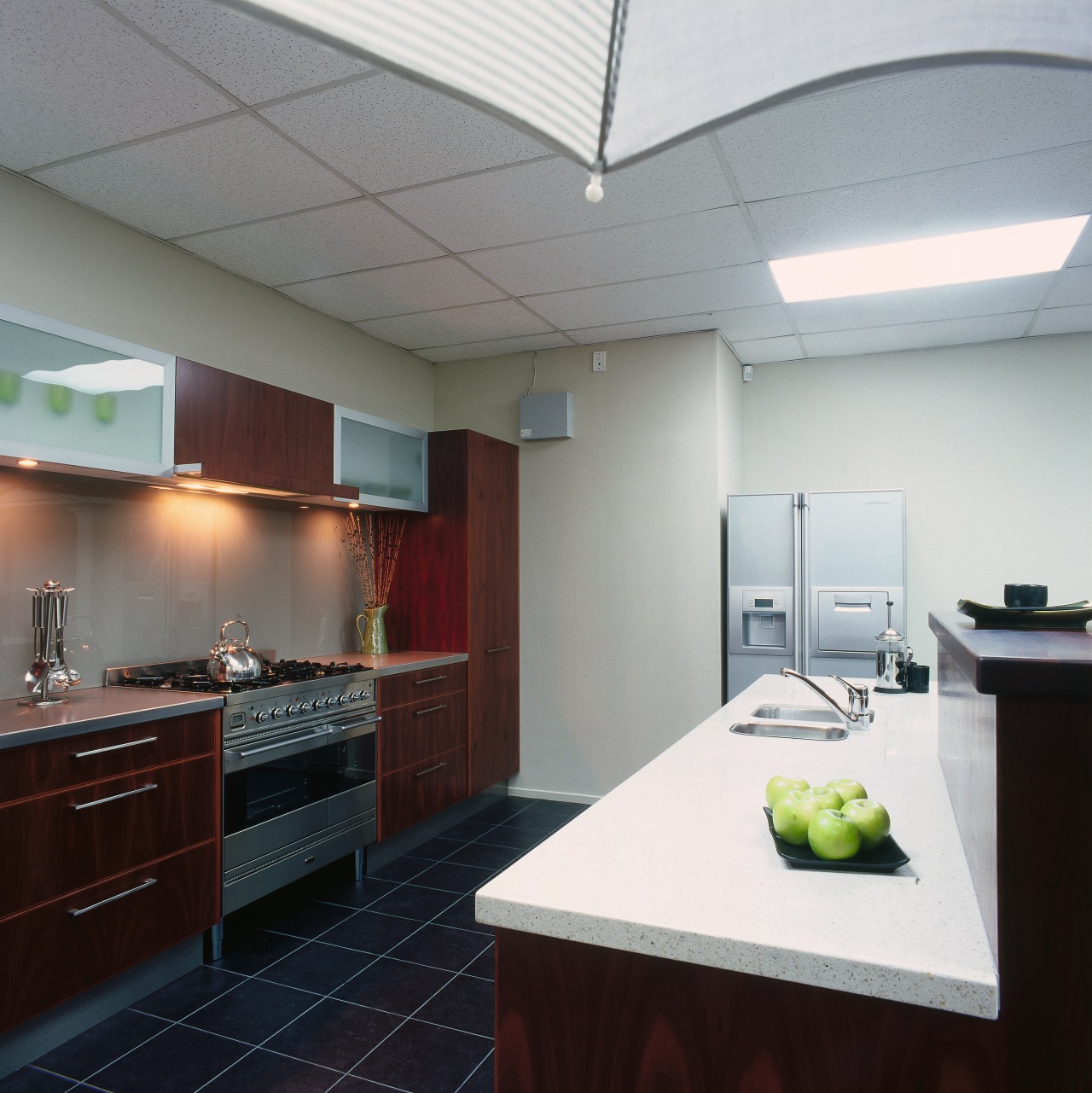 Showroom kitchen with dark timber cabinetry, white benchtop architecture, ceiling, countertop, daylighting, interior design, kitchen, real estate, room, gray, black