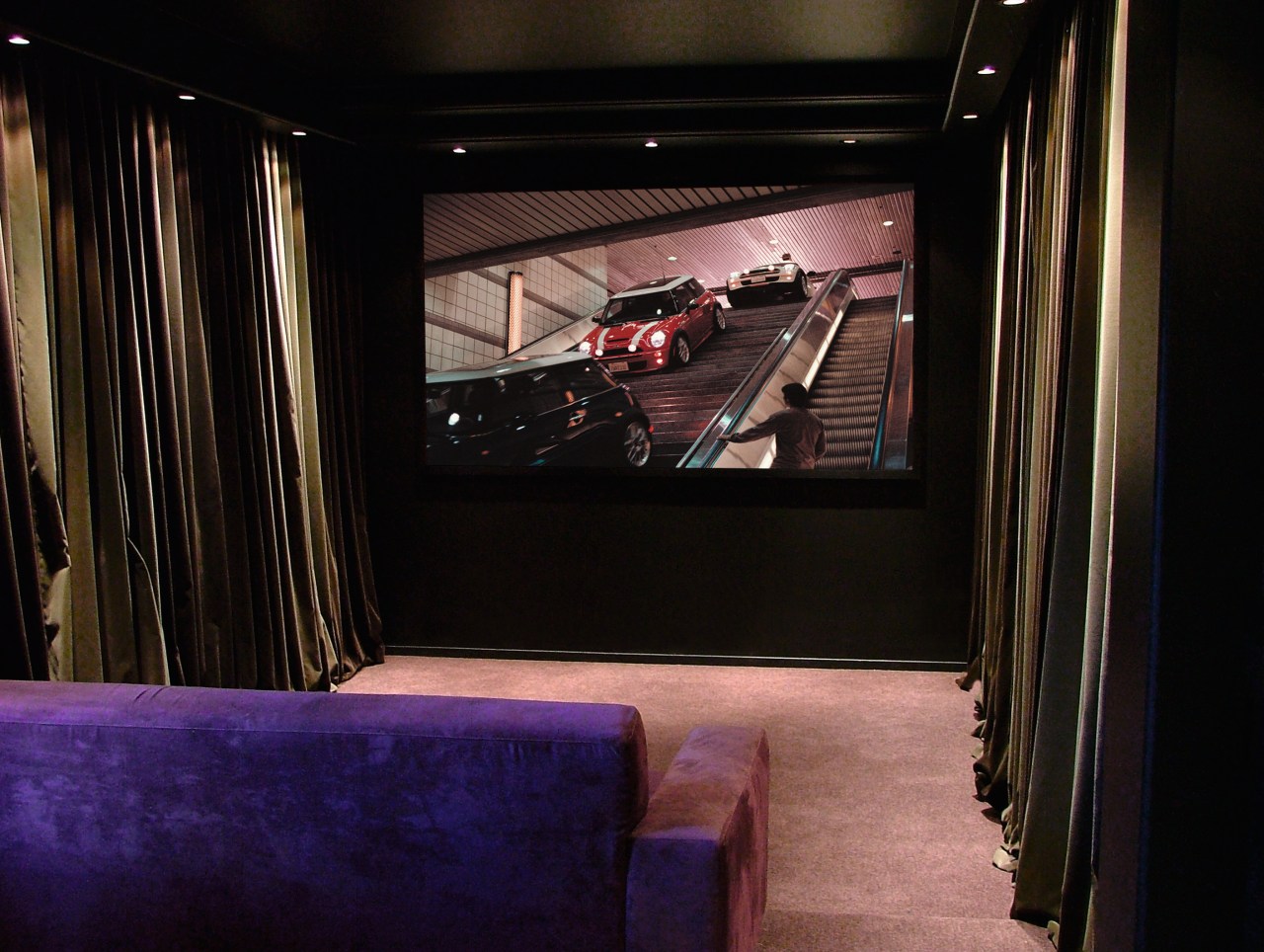 A photograph of a media room. The room darkness, entertainment, interior design, lighting, room, theatre, black