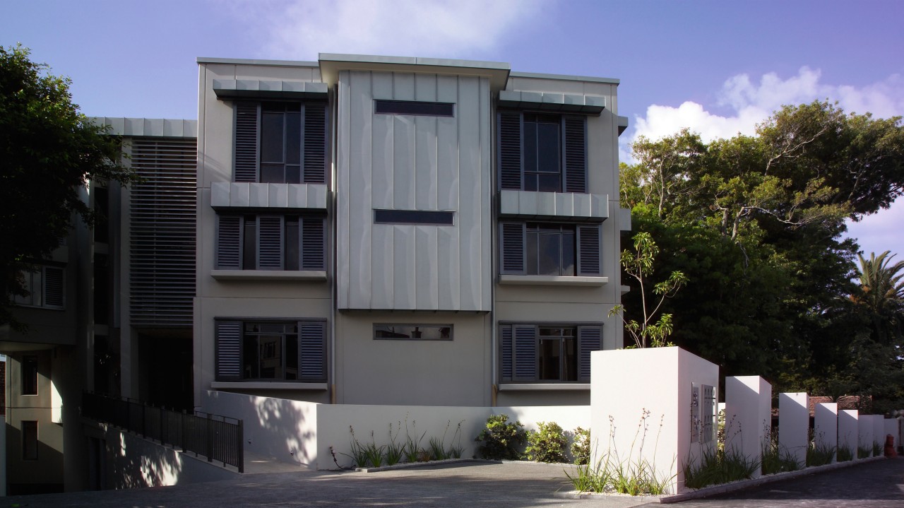 A photograph of a three storey apartment block. architecture, building, elevation, facade, home, house, neighbourhood, property, real estate, residential area, black