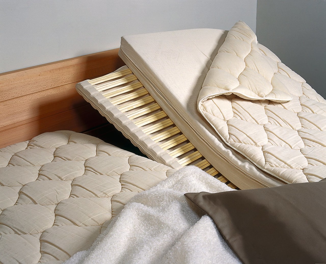 A photograph of the insides of a Huesler bed, bed frame, floor, flooring, furniture, mattress, mattress pad, product, product design, gray