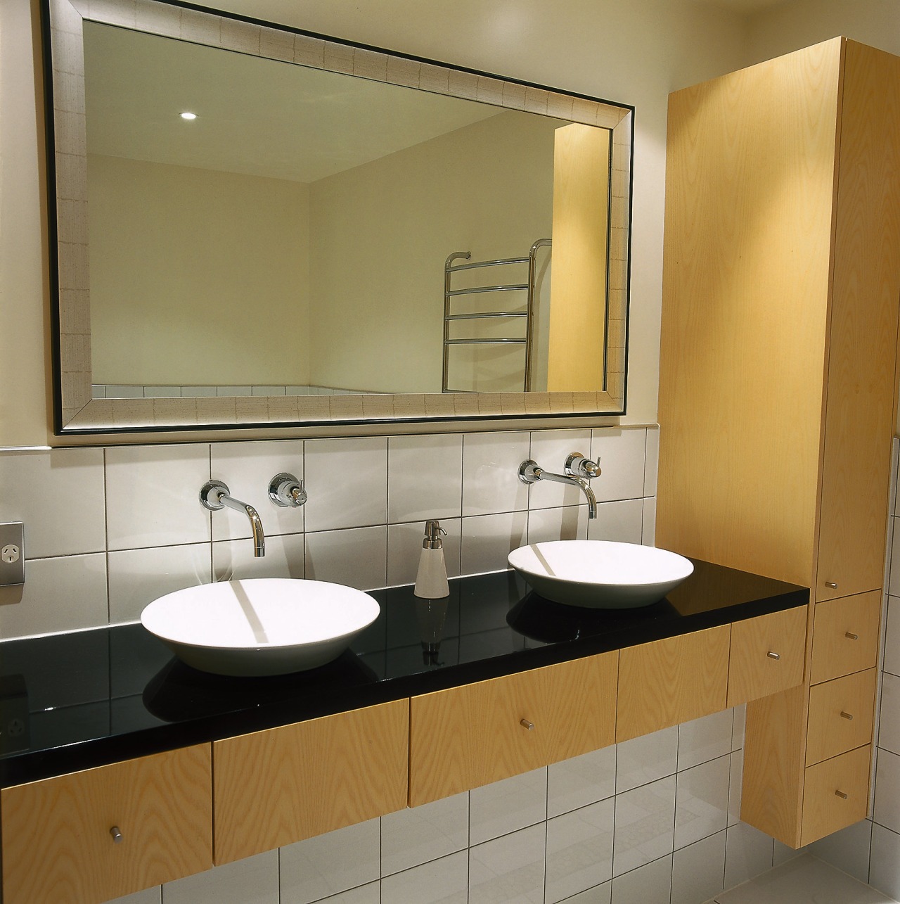 A bathroom featuring a large mirror, basins, taps bathroom, bathroom accessory, bathroom cabinet, countertop, interior design, plumbing fixture, product design, room, sink, brown