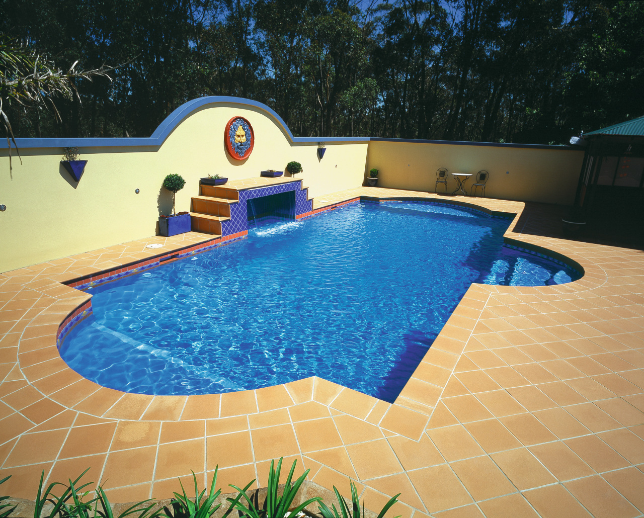 Blue pool with light tan coloured pavers, cream backyard, leisure, property, real estate, swimming pool, water, orange, black