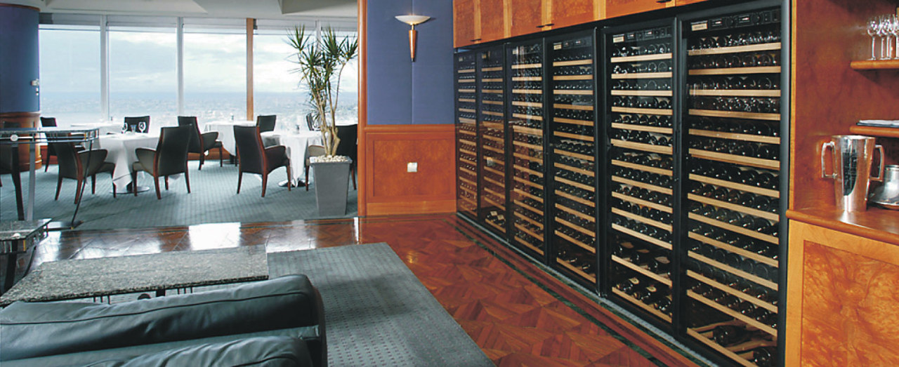 Wine storage cabinets along wall with seating area, floor, flooring, furniture, interior design, wood, black