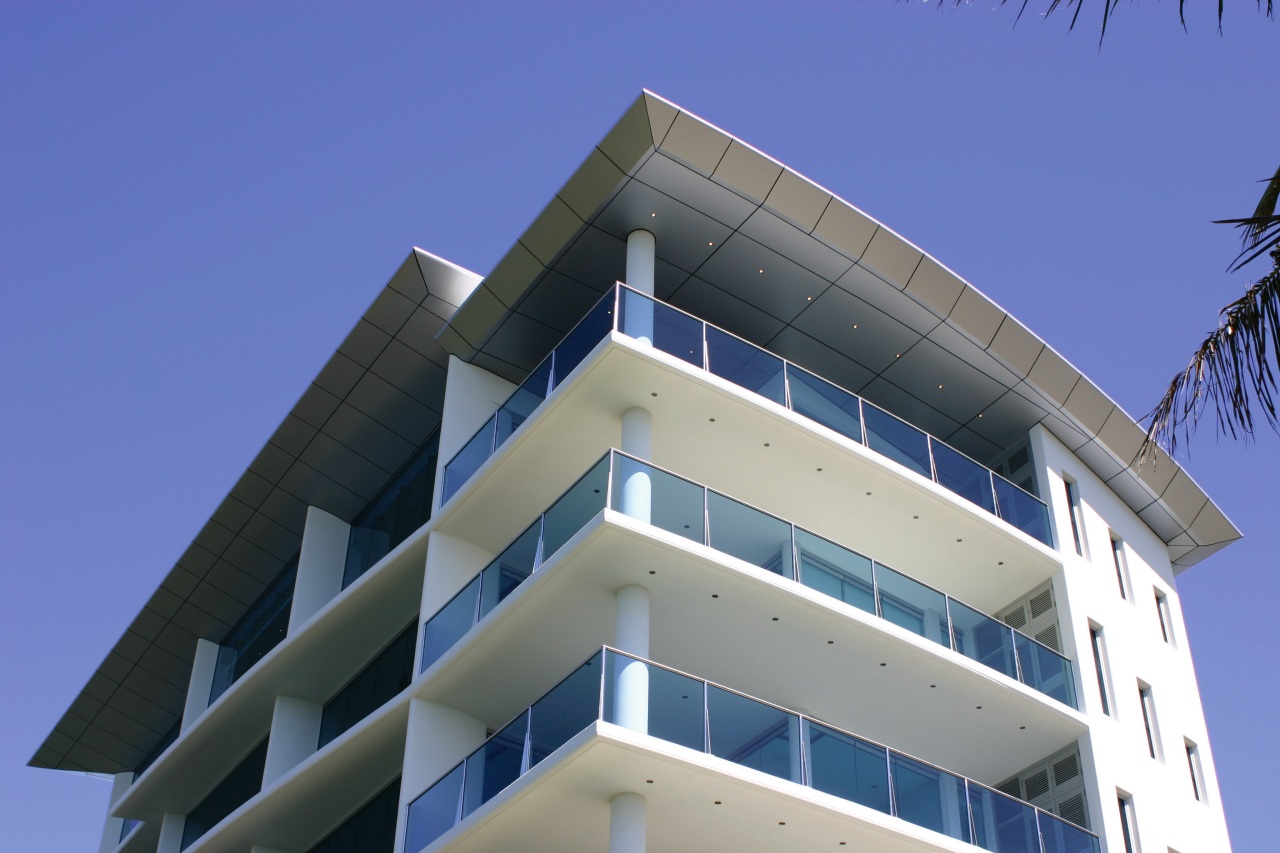 Exterior of multi-level apartment building with white cladding, apartment, architecture, building, commercial building, condominium, corporate headquarters, daylighting, daytime, elevation, facade, headquarters, mixed use, real estate, residential area, sky, tower block, blue