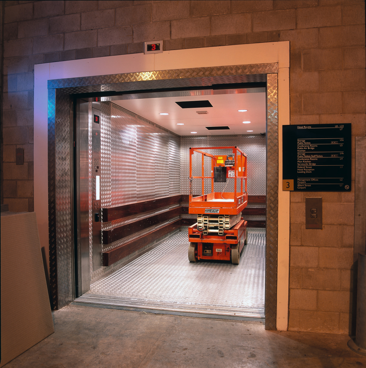 Service lift with heavy gauge aluminium chequer plates door, brown