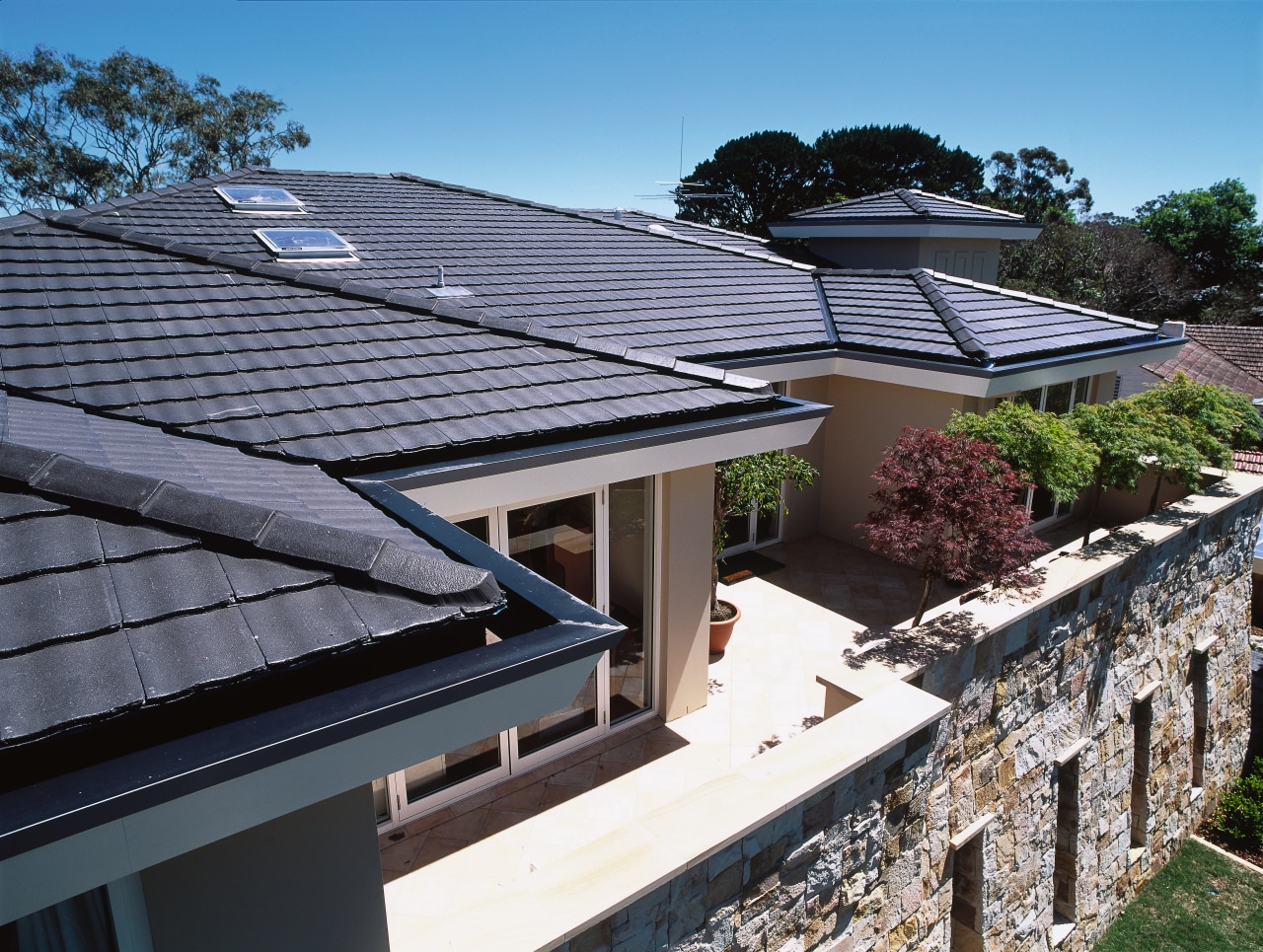 Balcony area of apartment complex featuring grey concrete daylighting, house, outdoor structure, real estate, residential area, roof, solar panel, solar power, black