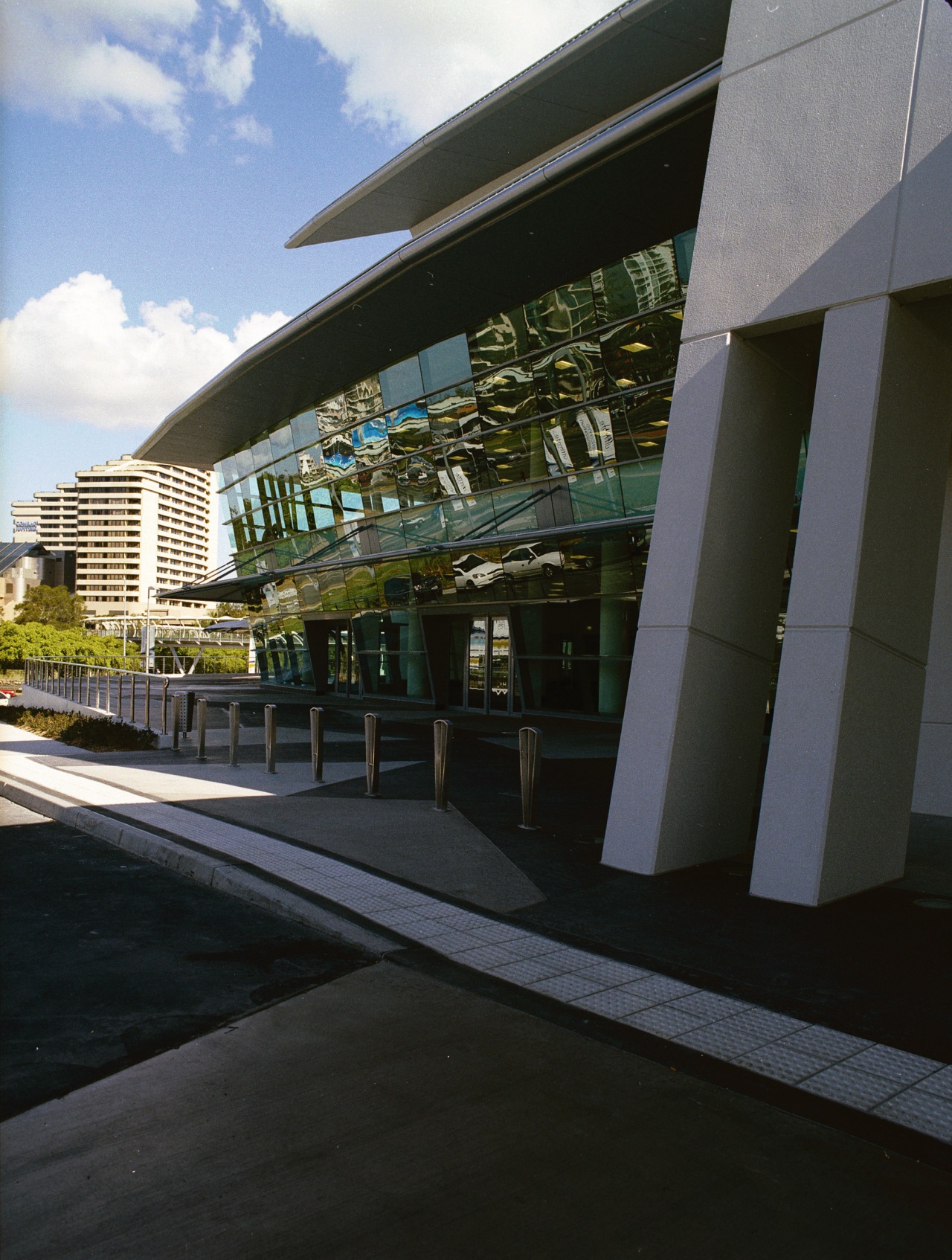 Exterior view of section of building showing sloping architecture, building, corporate headquarters, facade, metropolitan area, reflection, sky, structure, black