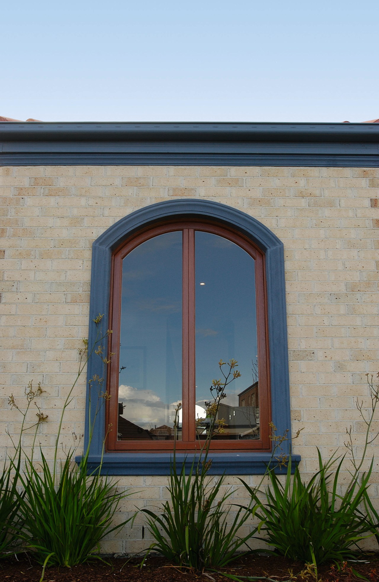 Exterior of brick clad house featuring timber arched arch, architecture, facade, home, sky, wall, window, teal, gray