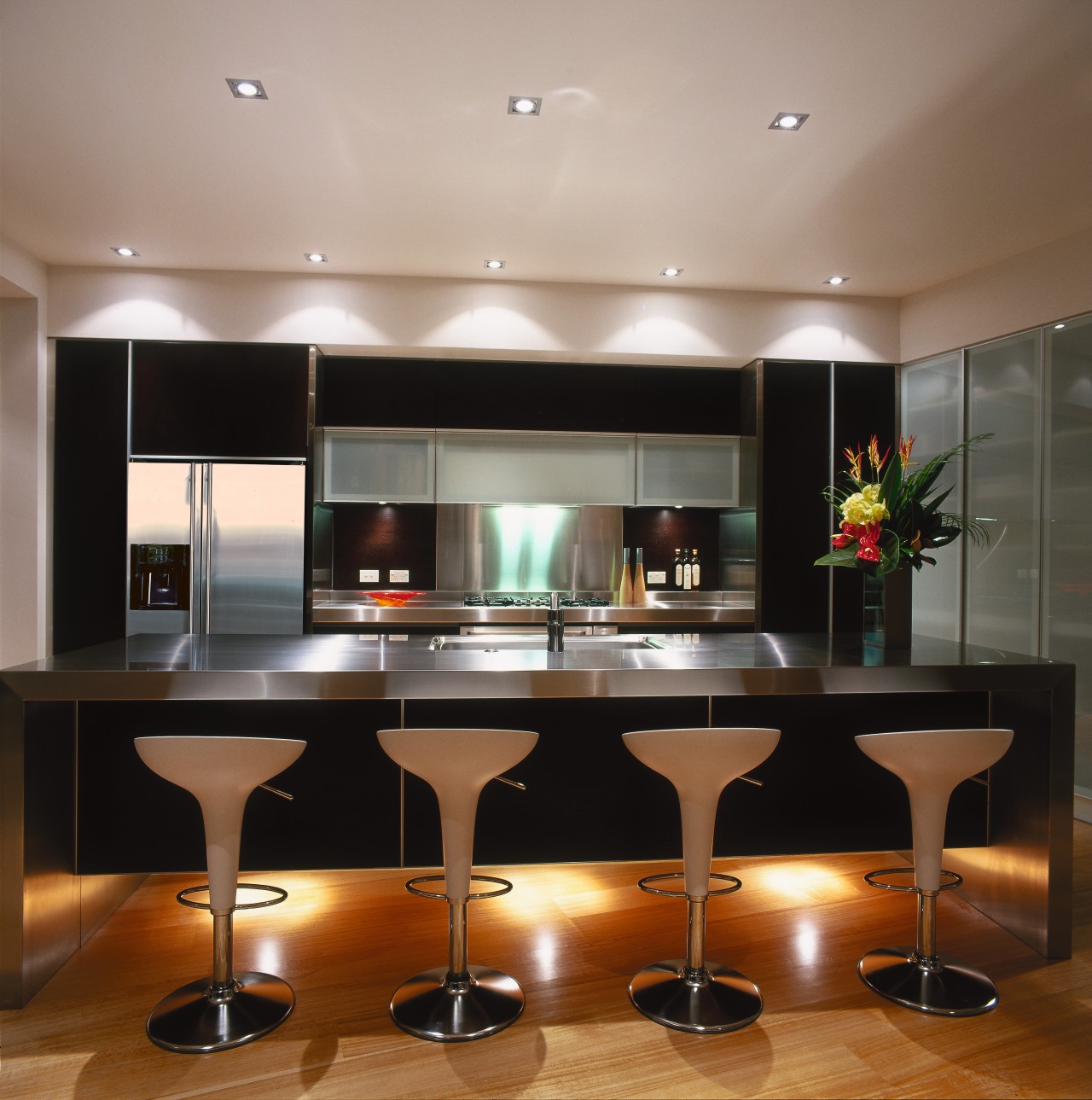 Kitchen with dark coloured cabinetry, four cream stools ceiling, countertop, interior design, kitchen, light fixture, lighting, table, gray, black, brown