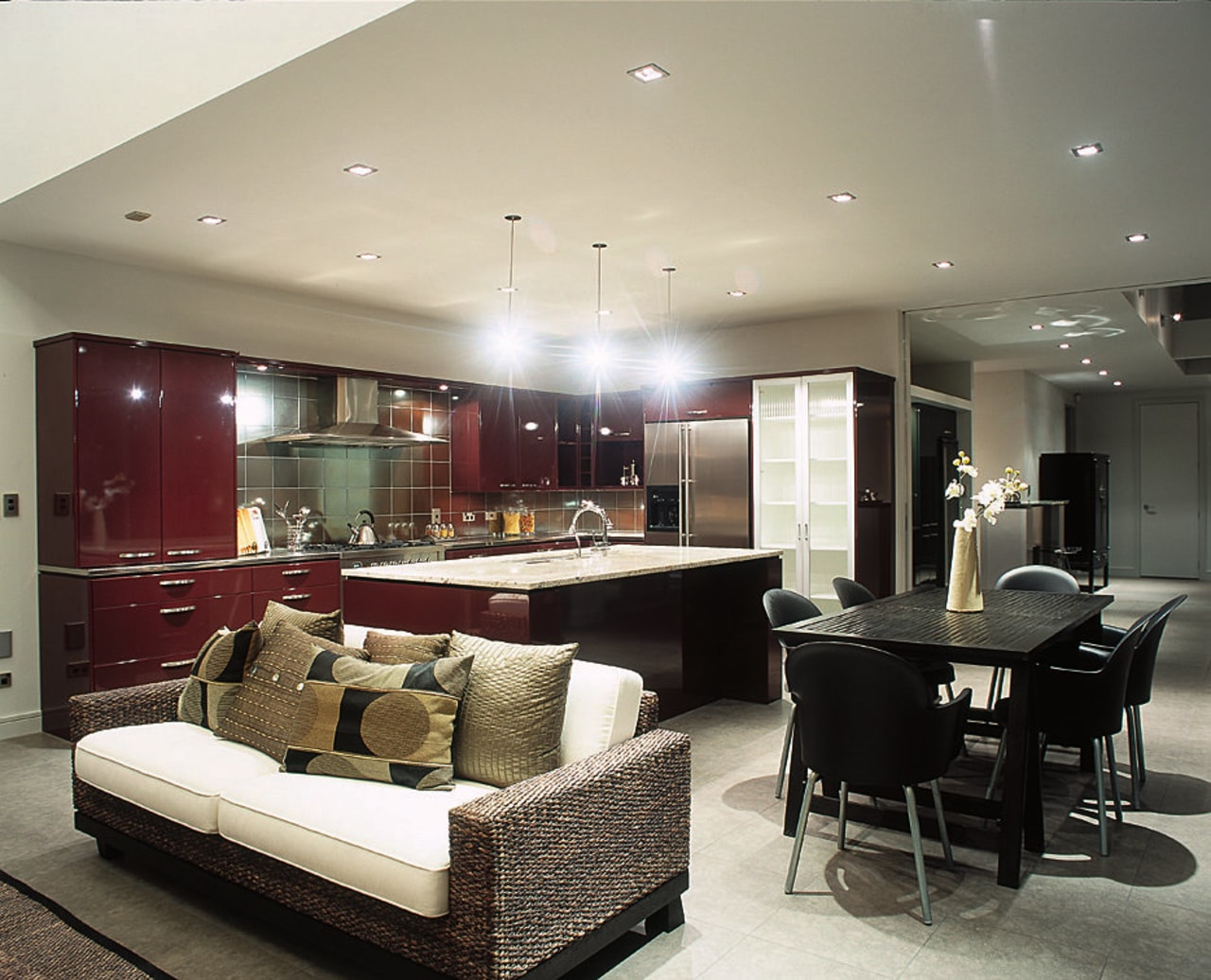 Open plan kitchen with red brown cabinetry, white ceiling, interior design, living room, room, gray, black
