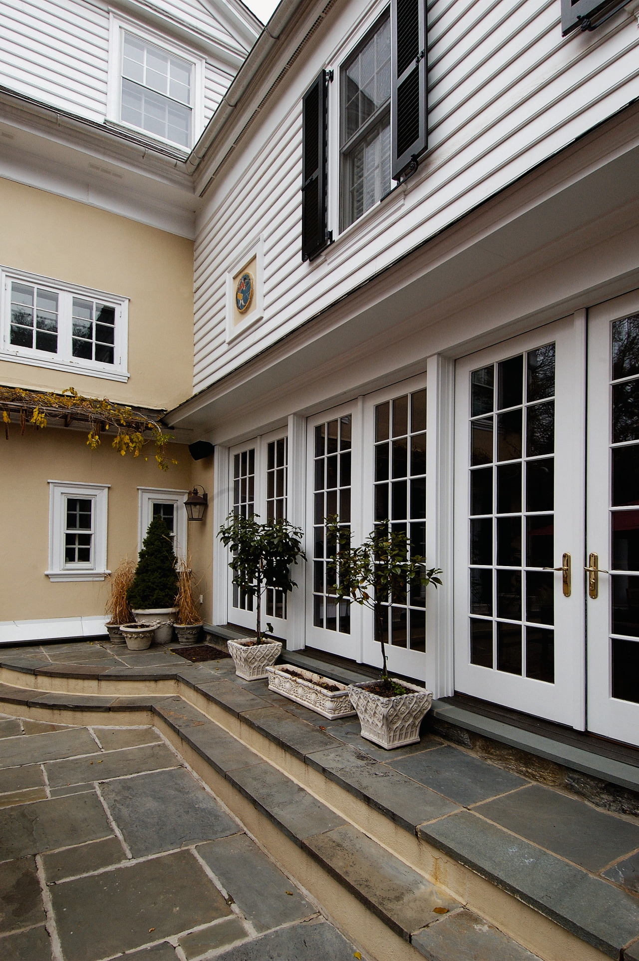 Exterior view of the patio area, large French building, courtyard, door, facade, home, house, outdoor structure, porch, siding, window, gray, black