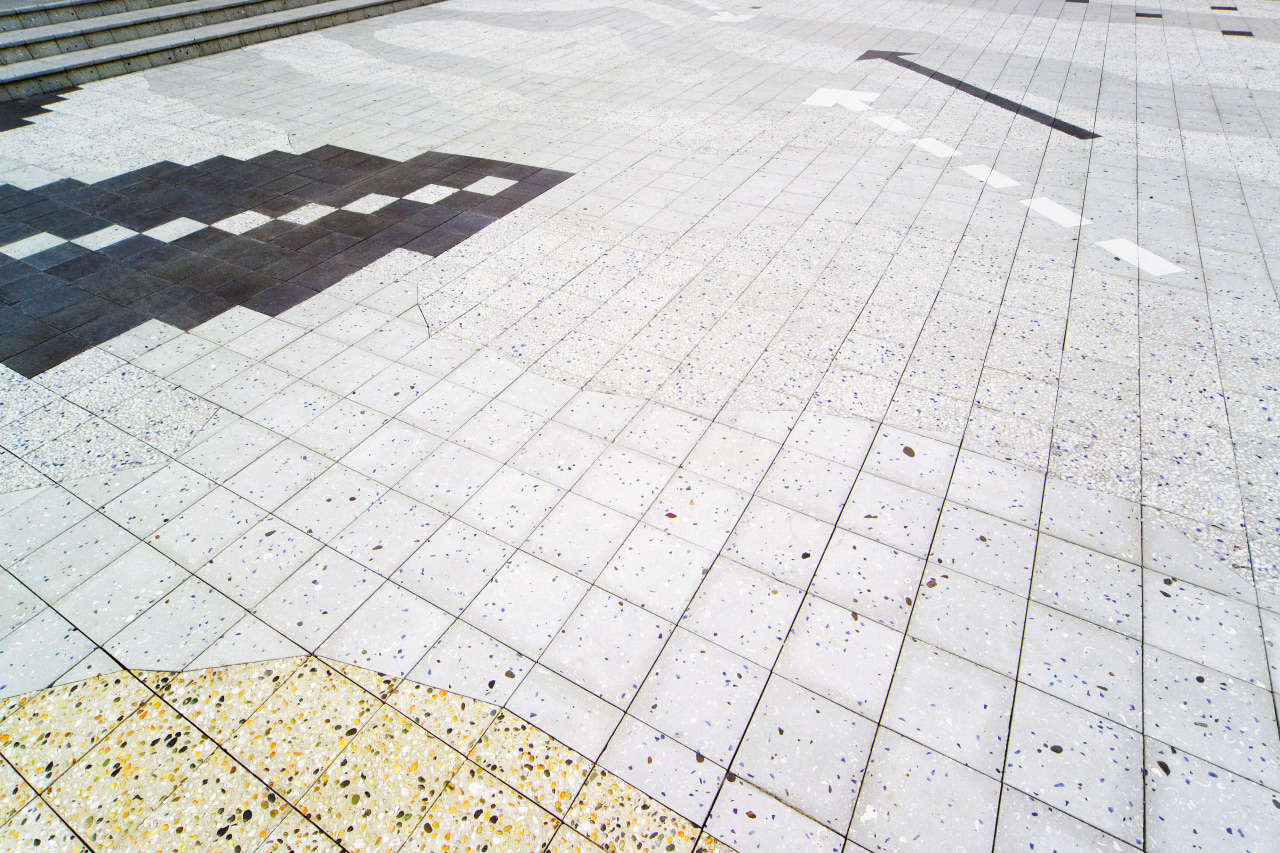Patterned tiles in paved courtyard. cobblestone, daylighting, floor, line, material, pattern, road surface, roof, walkway, white