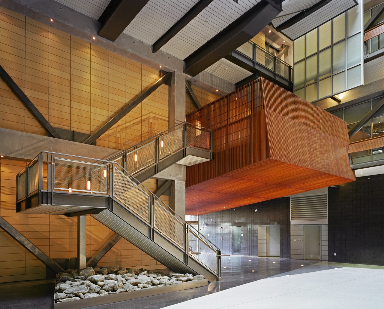 A view of the large metal rusty coloured architecture, building, daylighting, facade, stairs, wood, brown