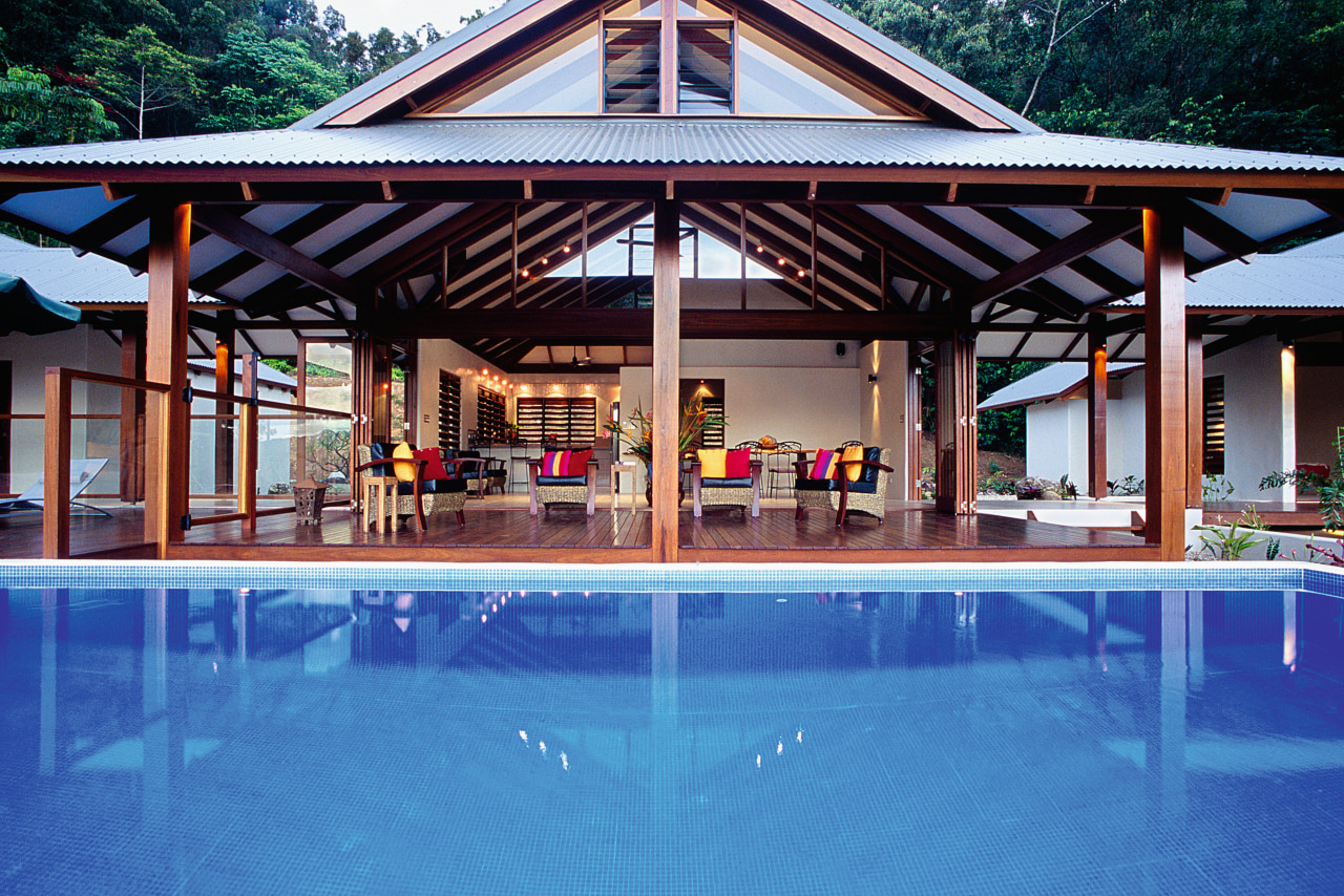 View of house across pool with timber floors, estate, leisure, outdoor structure, property, real estate, resort, swimming pool