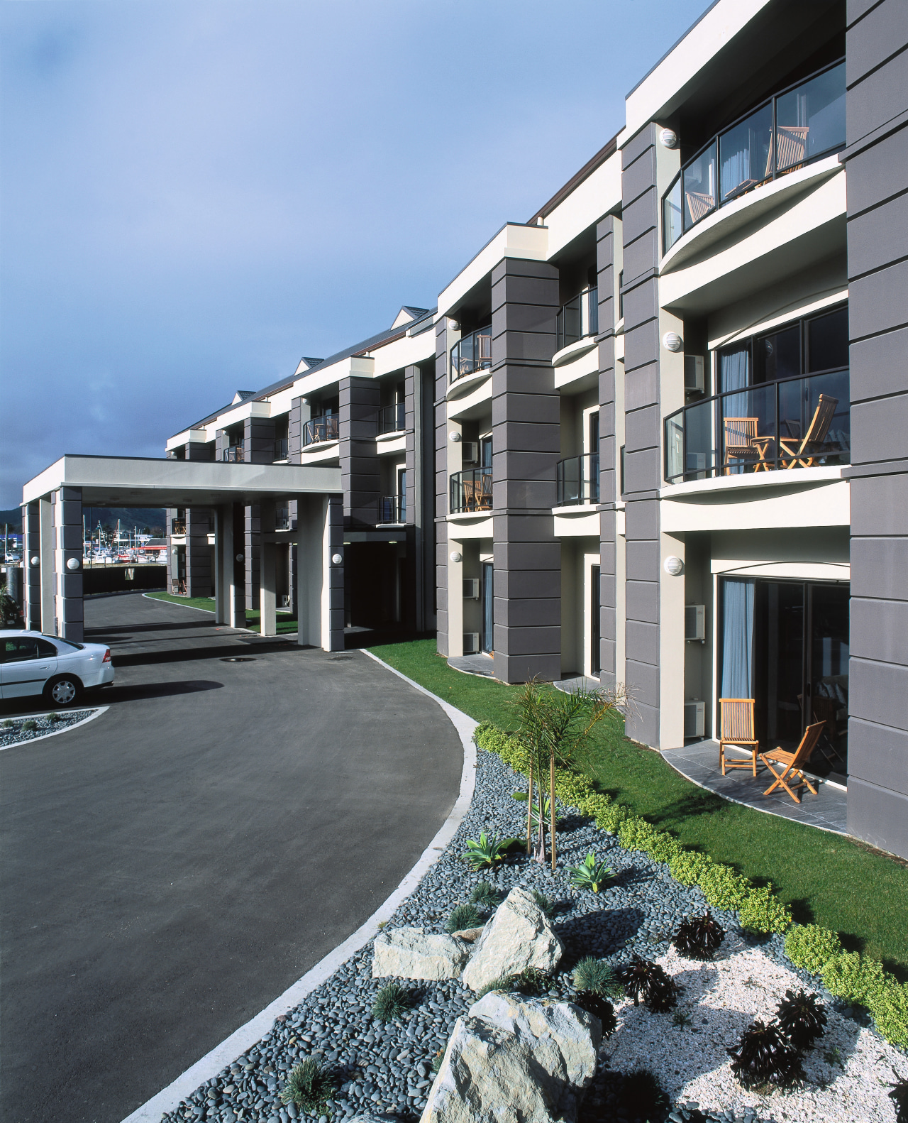 Exterior view of hotel entranceway with balconies at apartment, architecture, building, condominium, corporate headquarters, elevation, estate, facade, home, house, mixed use, neighbourhood, property, real estate, residential area, window, teal, gray, black