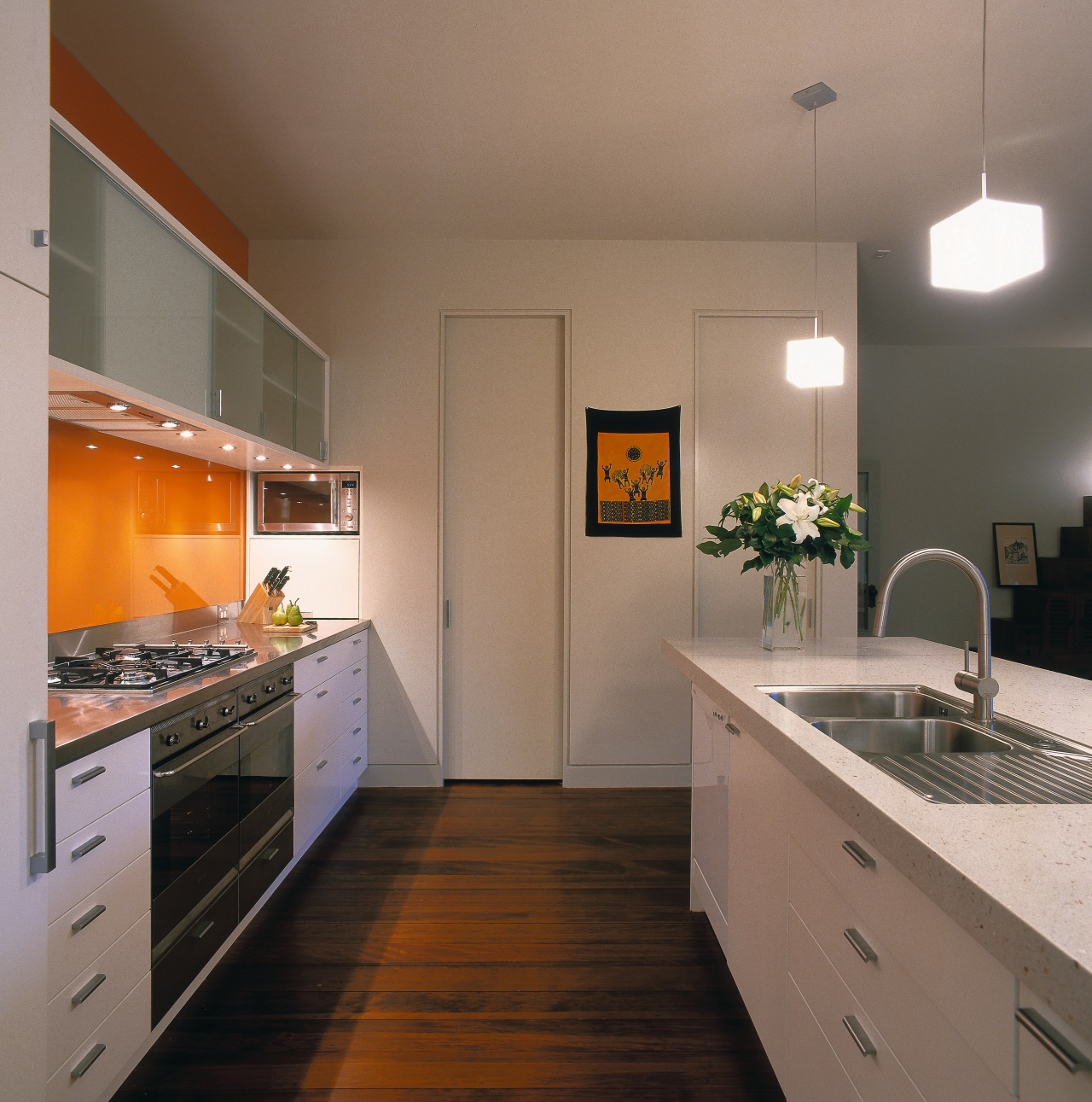 A view of a kitchen, wooden flooring, white cabinetry, countertop, interior design, kitchen, real estate, room, brown, gray