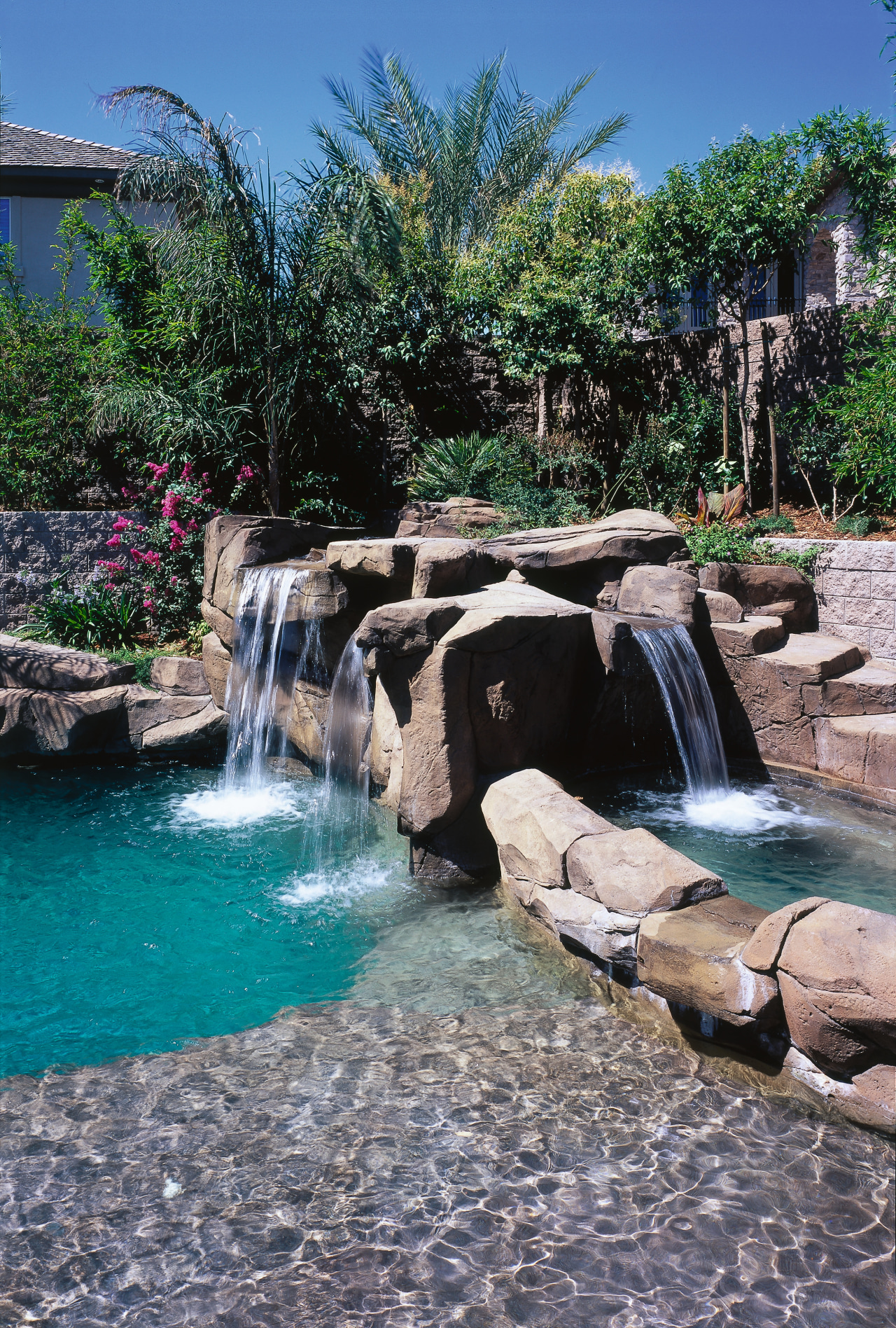 view of the pool area that includes a arecales, backyard, body of water, landscape, landscaping, leisure, pond, swimming pool, tree, water, water feature, water resources, watercourse, waterfall, gray, black