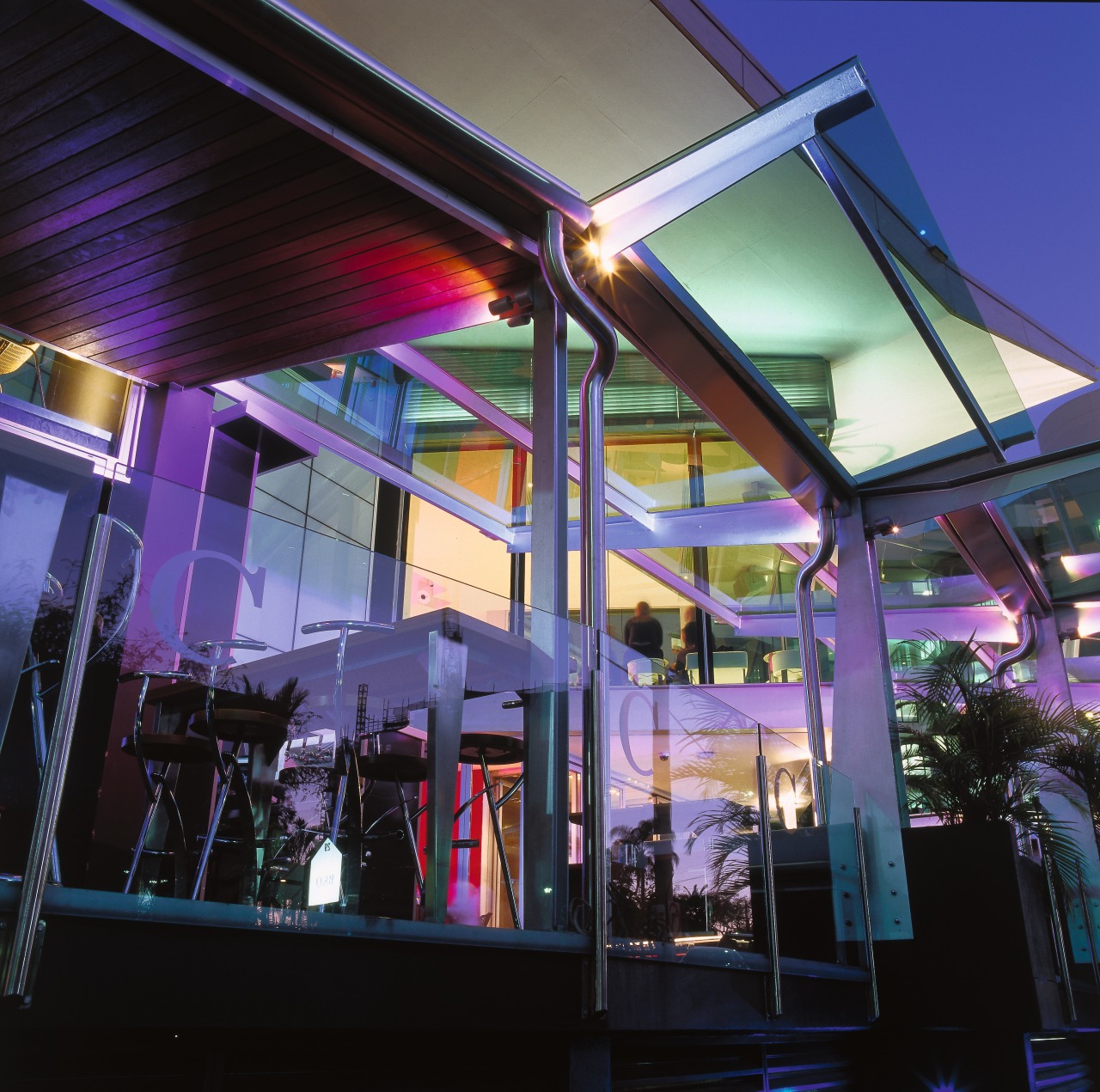 Exterior view of hotel building showing enclosed courtyard architecture, ceiling, light, lighting, night, purple, restaurant, black