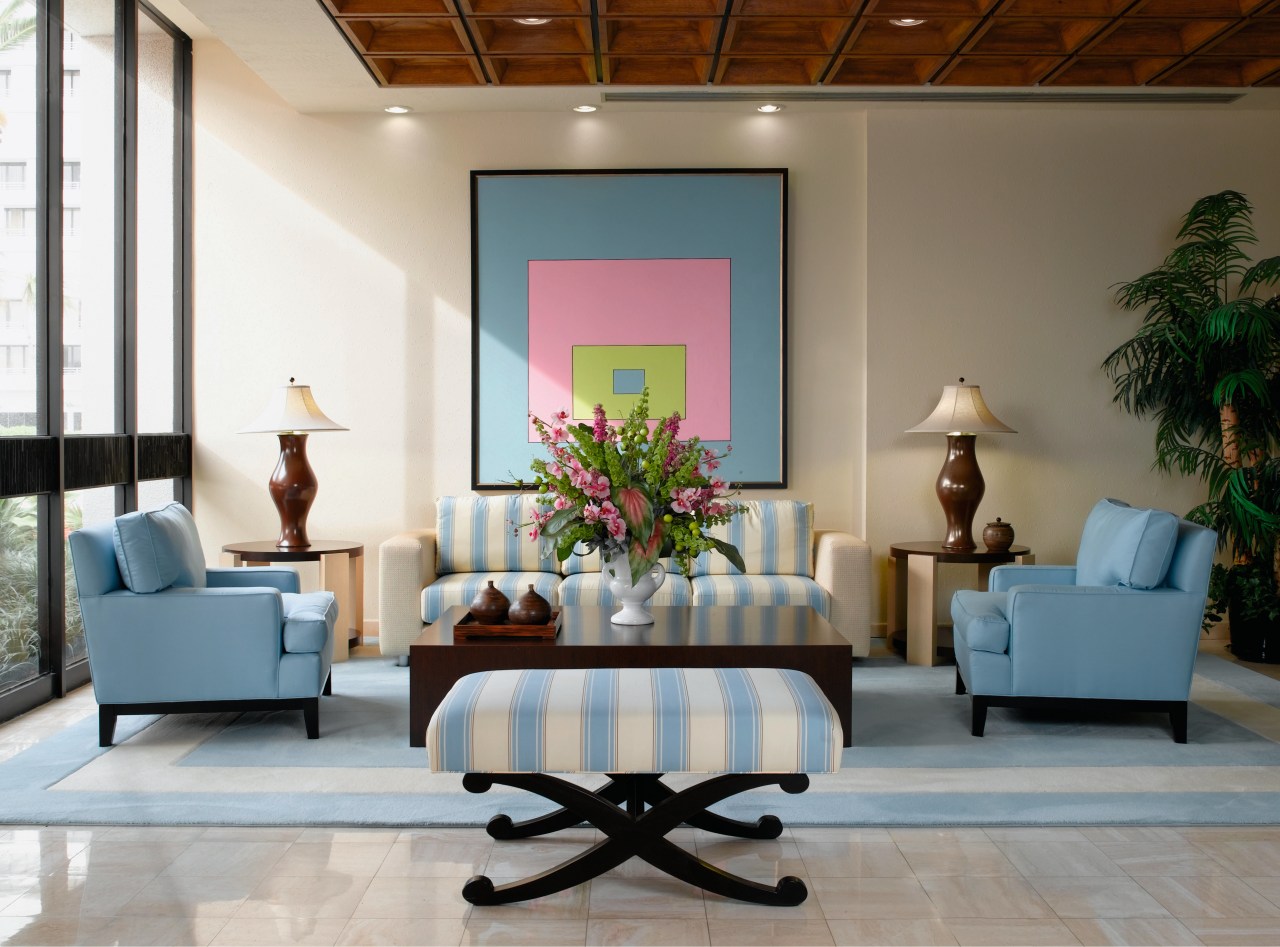 view of sthe lobby featuring pale blue furniture ceiling, furniture, interior design, living room, lobby, room, table, wall, gray