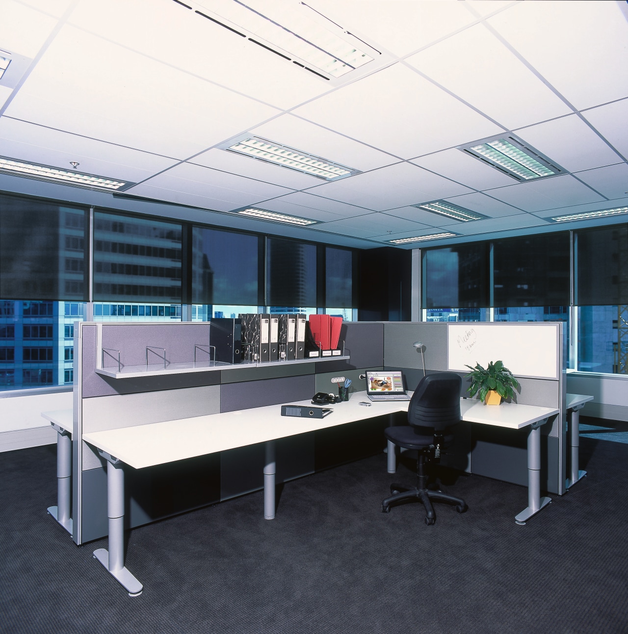 A view of the office area with many conference hall, desk, furniture, office, black, white