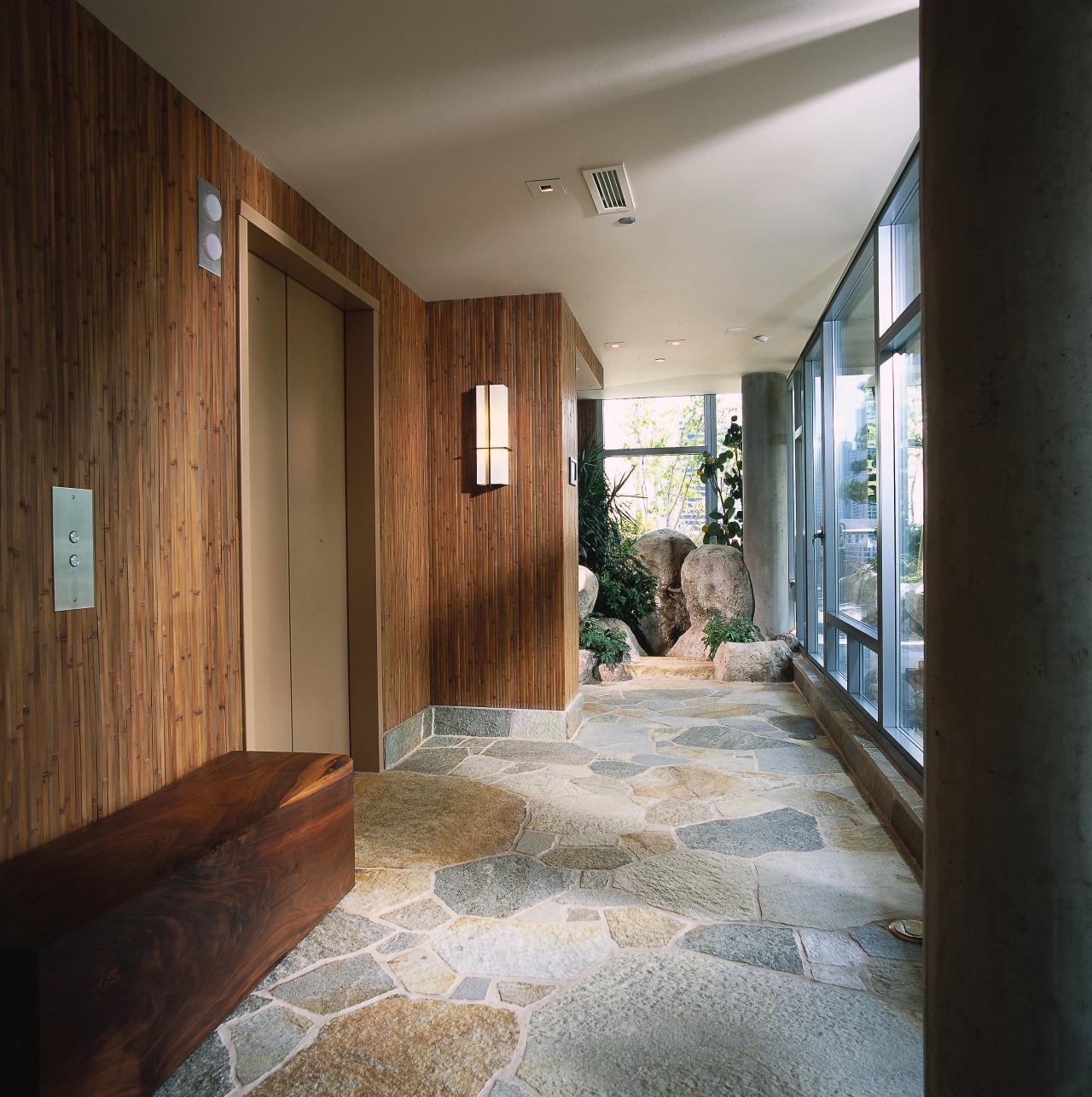 A view of a hallway, stone flooring, glass architecture, ceiling, daylighting, estate, floor, flooring, home, house, interior design, property, real estate, window, wood, black, gray